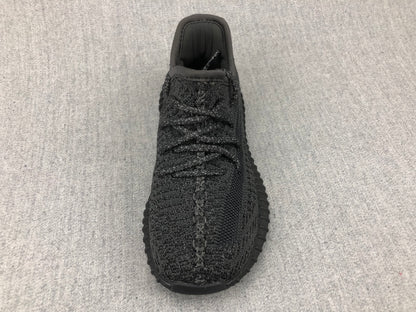 Top-down view of the black sneaker showing the laces, tongue, and knit-look upper.