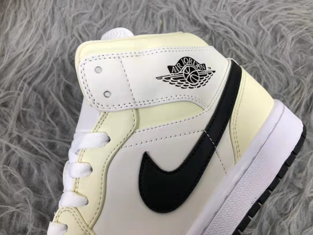 Close-up of the padded collar, ankle panel, stitching, and black side design on the cream and white sneaker.