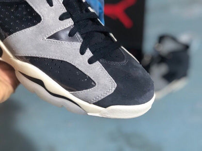 Close-up of the toe area showing black laces, a light grey overlay, perforated black paneling, and a rounded white toe edge.