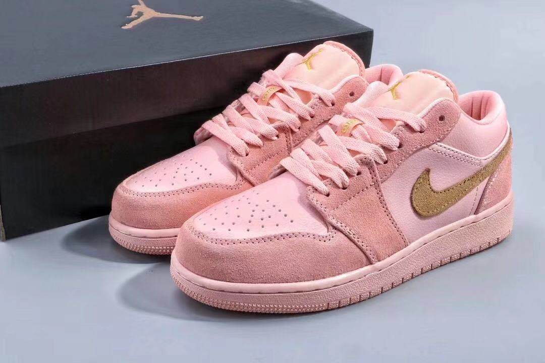 Pair of pink low-top Jordan sneakers displayed with a black shoebox.