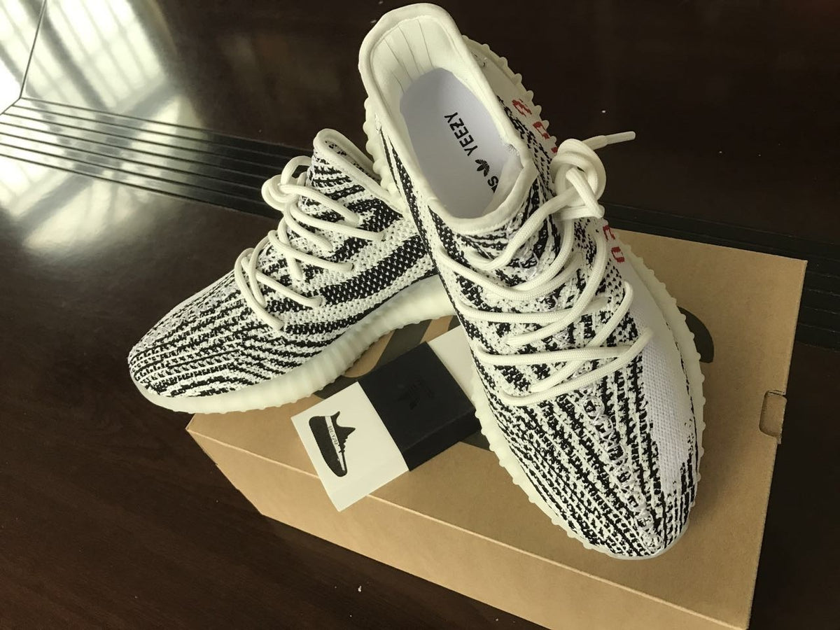 Top view of the black-and-white patterned sneakers with white laces and translucent soles.