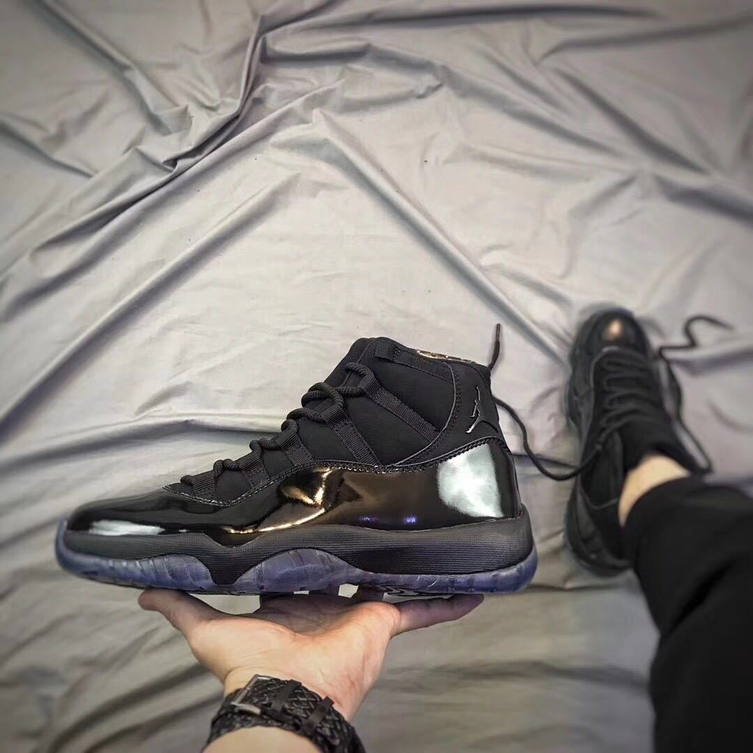 Side profile of a black high-top sneaker held above a light fabric backdrop.