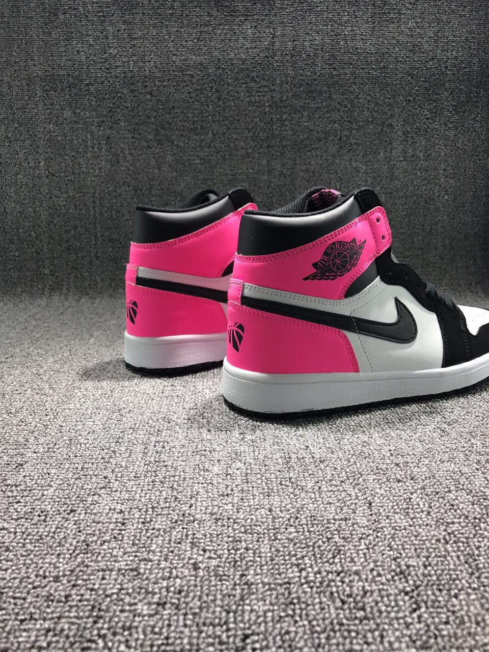 Rear three-quarter view highlighting the pink heel panels, black collars, white midsoles, and contrasting side details.