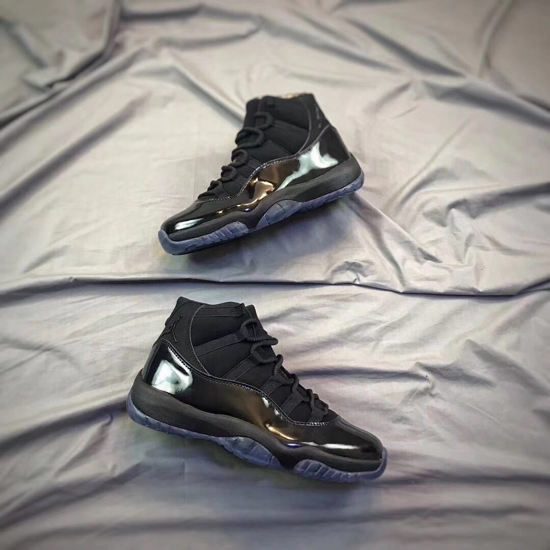 Pair of black high-top sneakers shown from an angled side view on a light fabric backdrop.