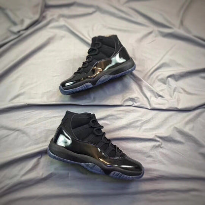 Pair of black high-top sneakers shown from an angled side view on a light fabric backdrop.