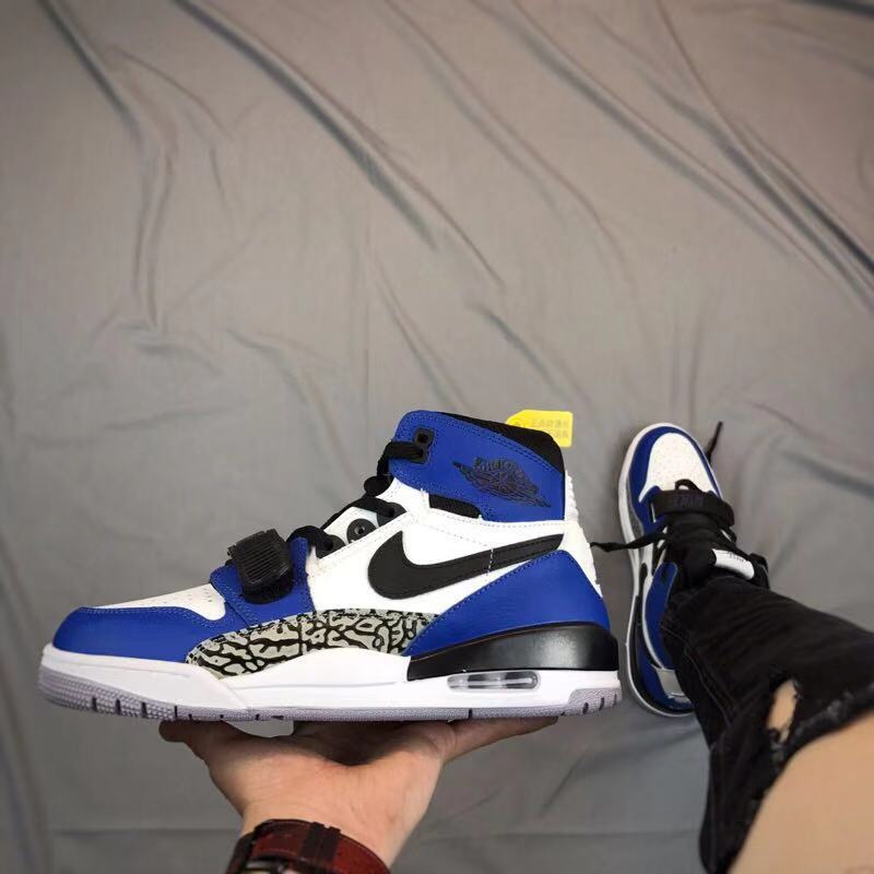 Side view of a blue, white, and black high-top sneaker with an elephant-print panel and adjustable strap.