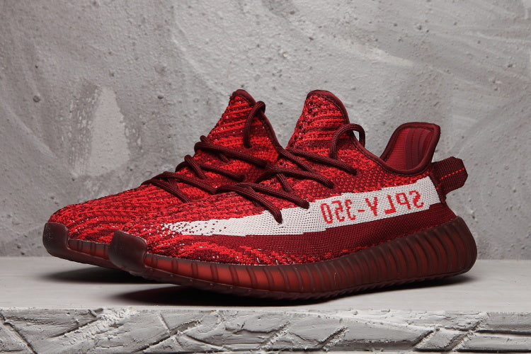 Pair of burgundy Yeezy 350 V2-style sneakers shown from a front three-quarter angle.