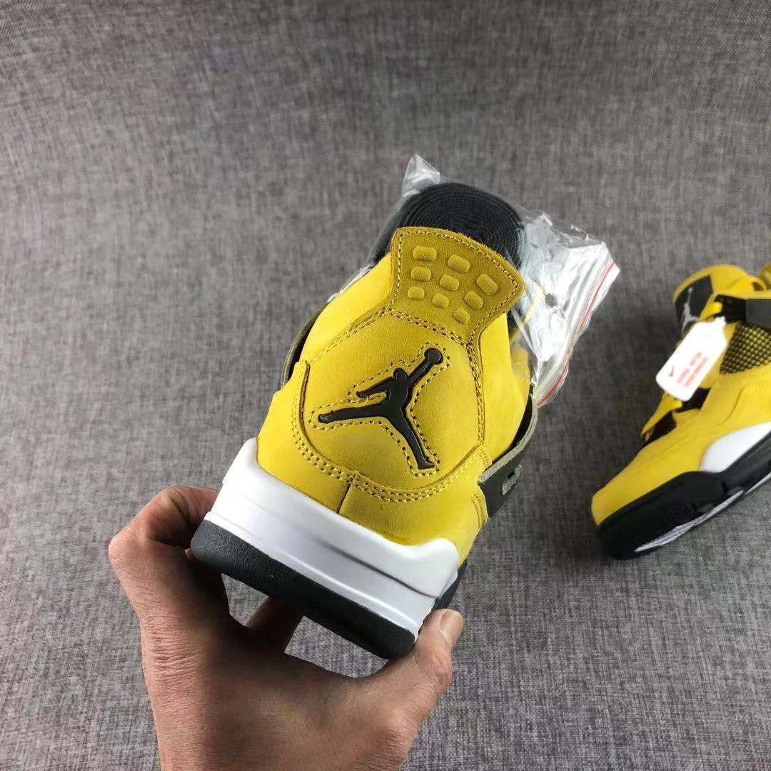 Rear view showing the yellow heel, black Jumpman emblem, white midsole, and black outsole.