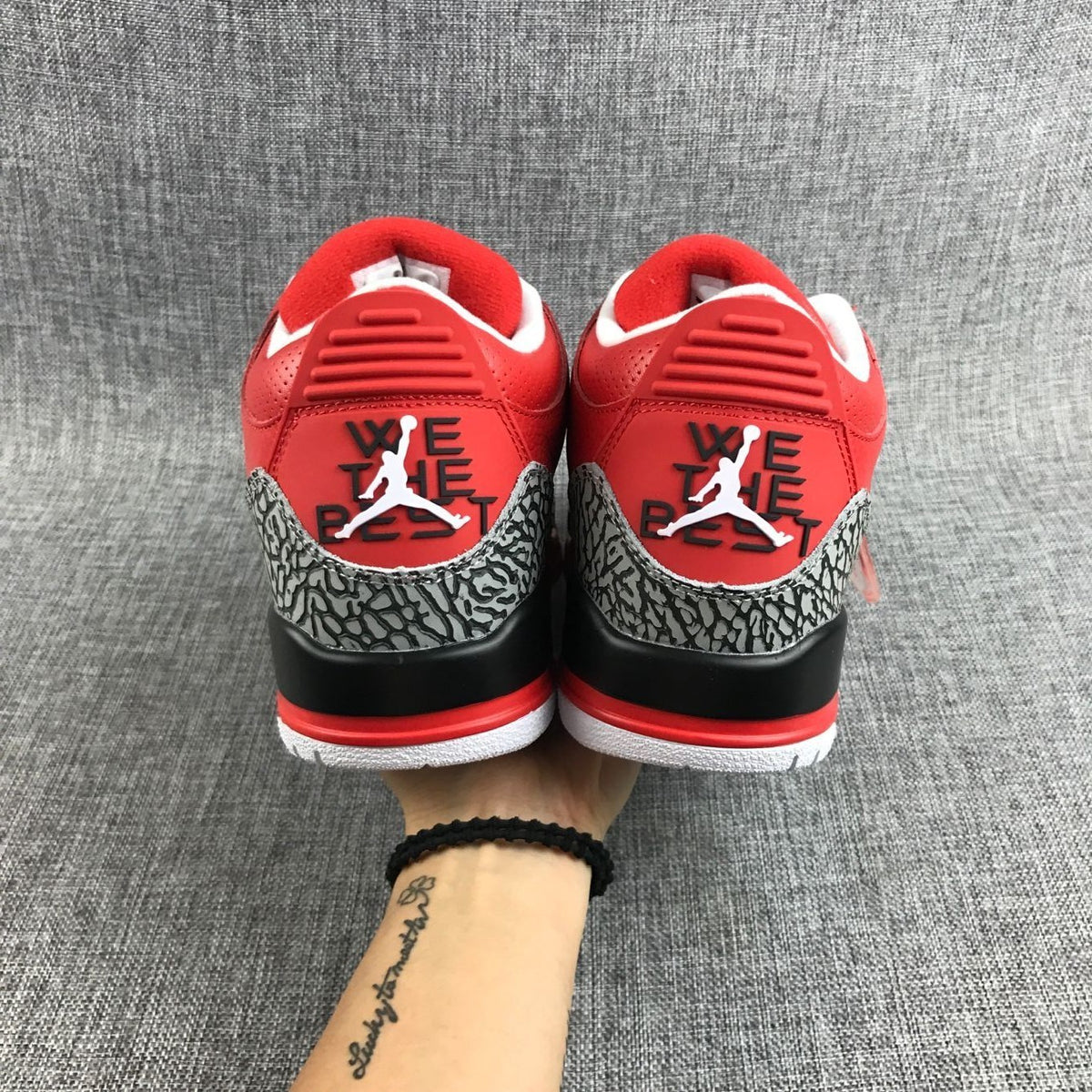 Rear view of the pair with red heel panels and elephant-print overlays.