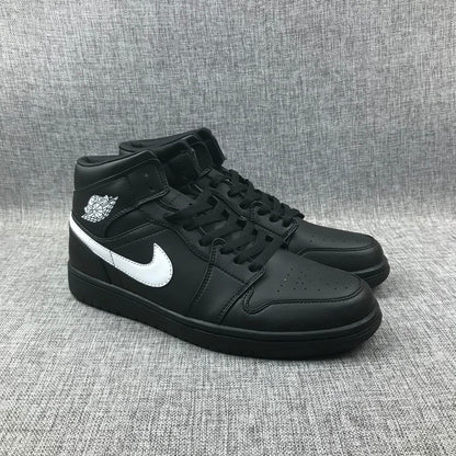 Three-quarter front view of the black and white mid-top sneaker pair.