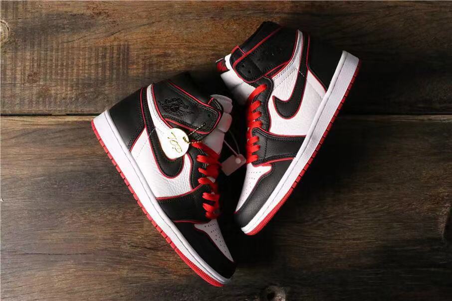 Top-down view of the pair showing the black, white, and red color blocking and a gold-colored decorative tag.