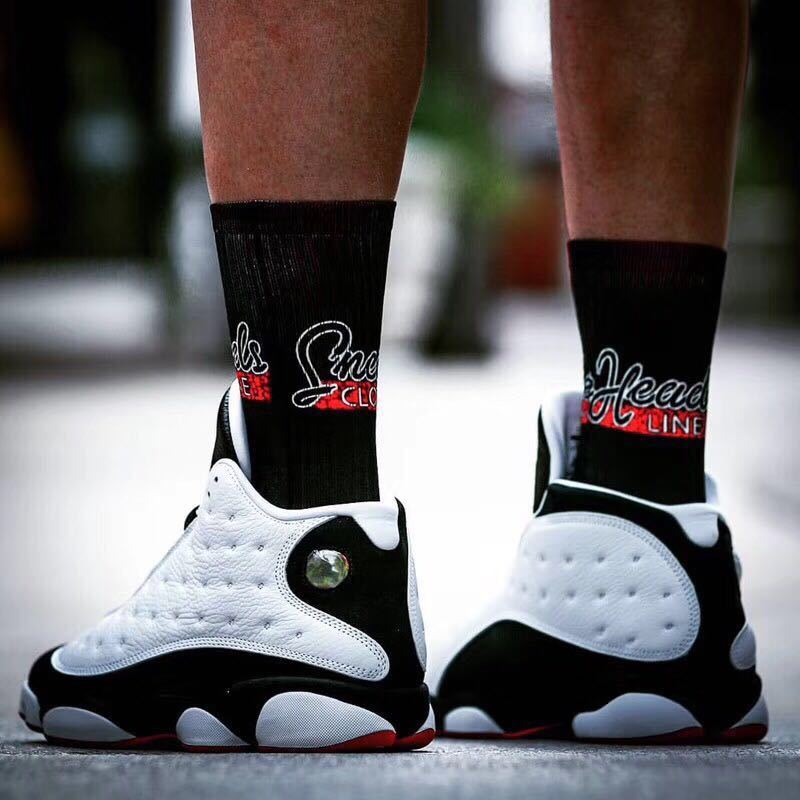 Rear view of the sneakers showing the white heel panels, black sections, and red outsole trim.