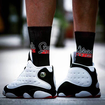 Rear view of the sneakers showing the white heel panels, black sections, and red outsole trim.