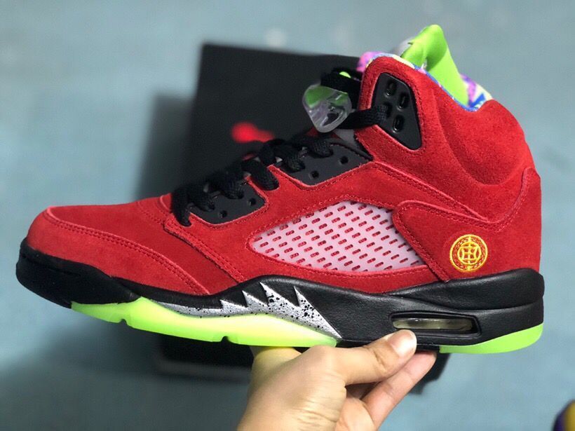 Side profile of the red high-top sneaker with black accents, mesh panel, translucent outsole section, and visible heel cushioning unit.