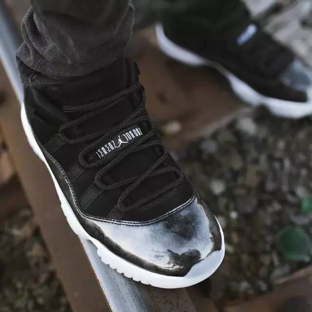 Close lifestyle view of one sneaker being worn, showing black laces and a silver-black toe panel.