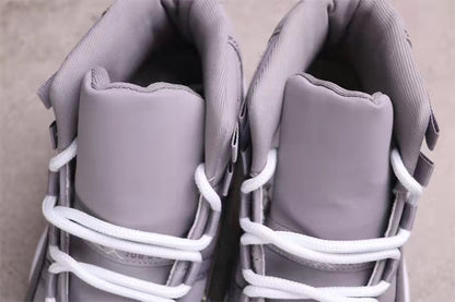 Top view showing the padded tongues, collars, and white laces of the grey high-top sneakers.