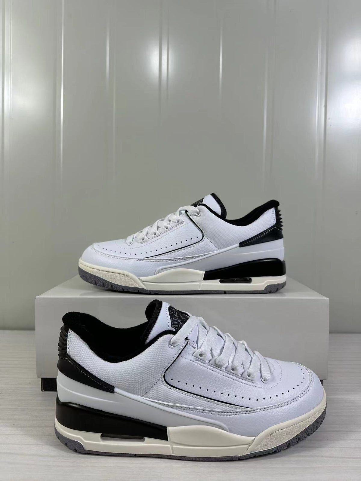 Three-quarter product view showing the white and black colorway and layered sole construction.