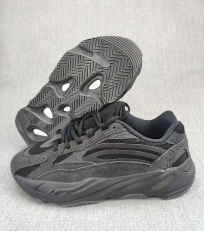 Charcoal and gray 700 V2 sneaker shown from the side with the patterned outsole visible.