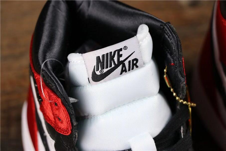 Close-up of the white tongue label, black laces, and red-and-black upper panels.