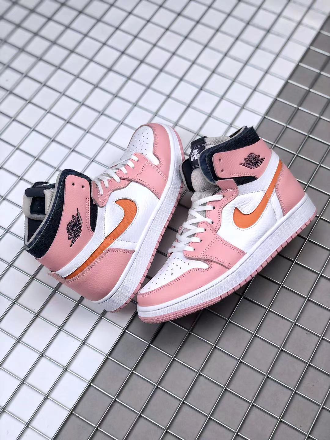 Pair of pink, white, orange, and black high-top sneakers displayed together.