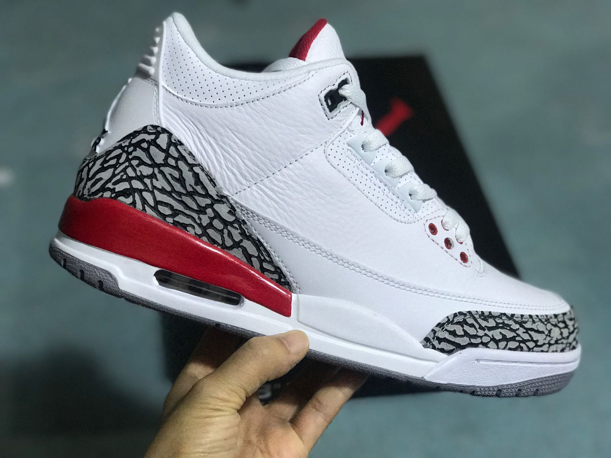 Angled side view of a white Jordan 3 Retro sneaker with gray elephant print and red accents