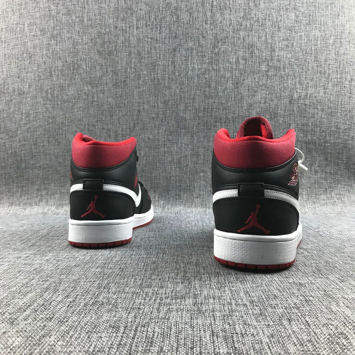 Rear view of the pair showing red collars, black heel panels, white accents, and red Jumpman details.