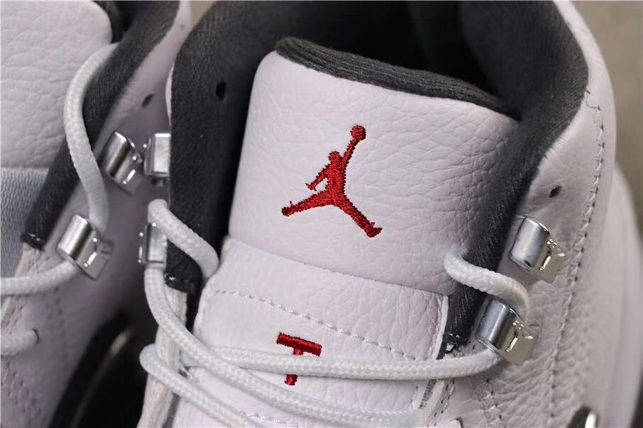 Close-up of the white tongue with a red Jumpman logo, white laces and metal lace hardware.