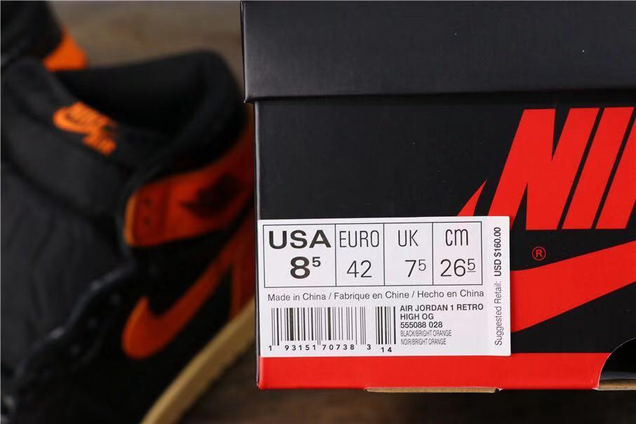 Black and orange high-top sneaker beside a shoebox showing a size label with EU 42 and the model name Air Jordan 1 Retro High OG.