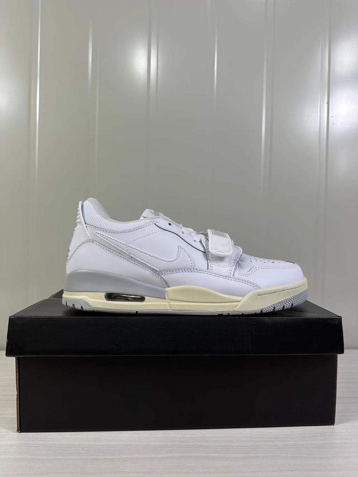 Opposite side profile of the white low-top sneaker with a perforated toe and textured outsole.