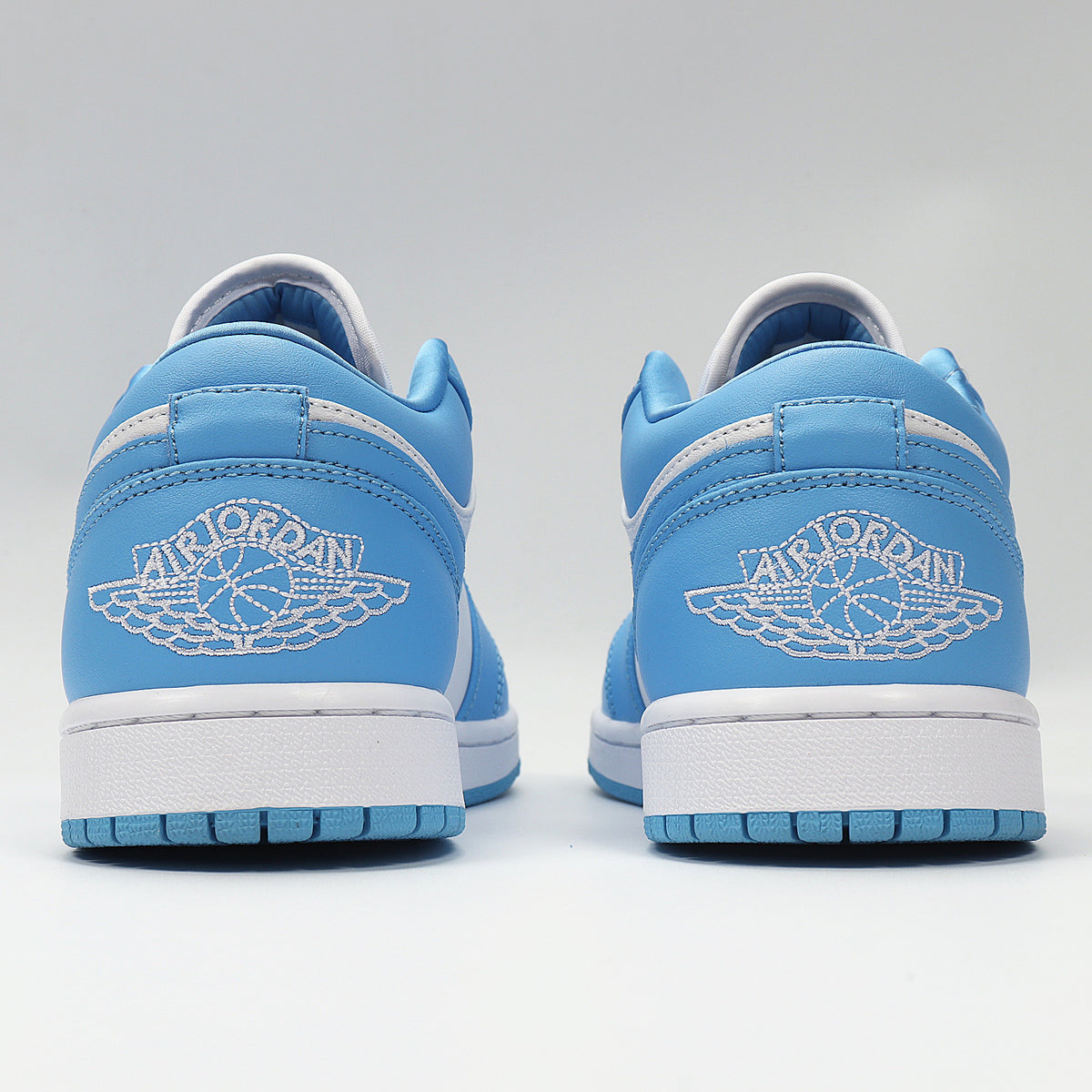 Rear view showing blue heels, white winged basketball embroidery, and blue outsoles.