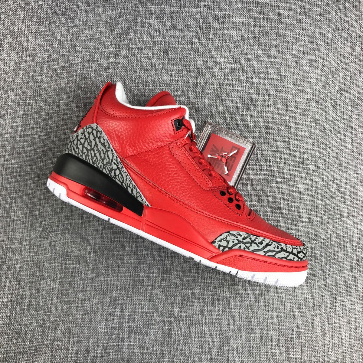 Angled view highlighting the red upper and elephant-print panels on the toe and heel.