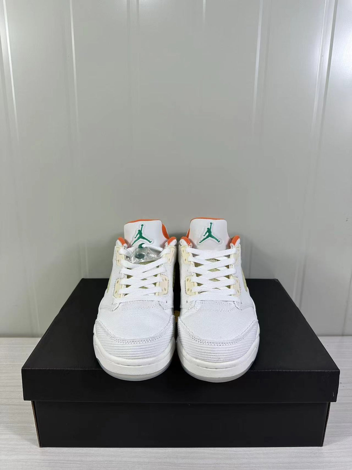 Front view of the pair showing white laces, tongue logos, and orange tongue and collar accents.