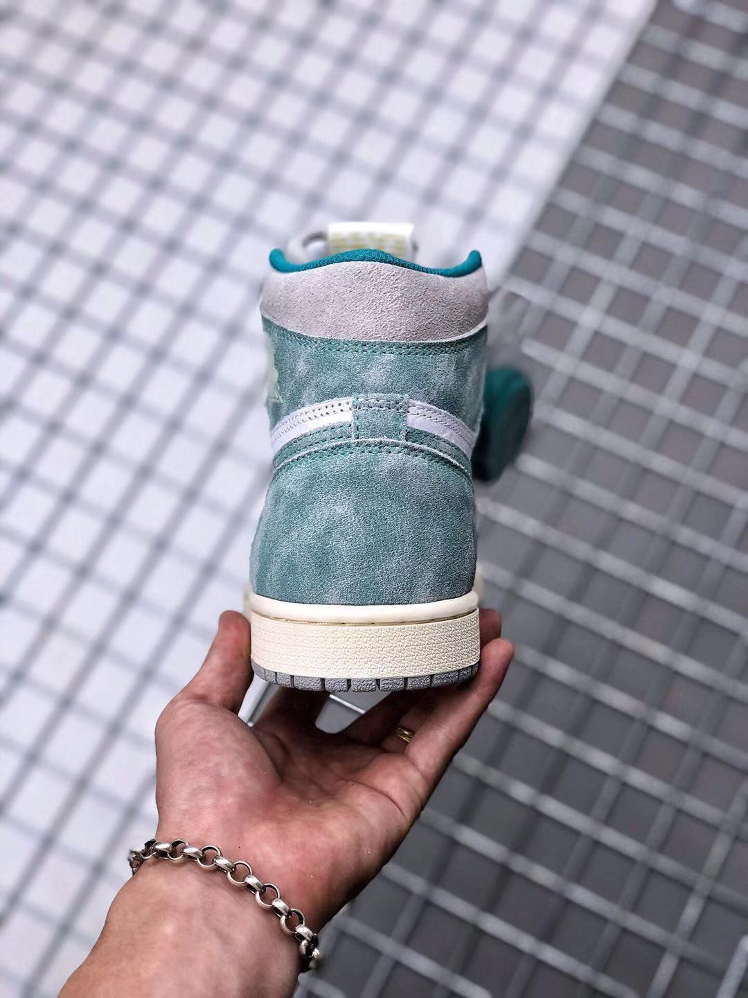 Rear view of the high-top sneaker showing the teal-green heel, light grey collar, and cream-colored midsole.