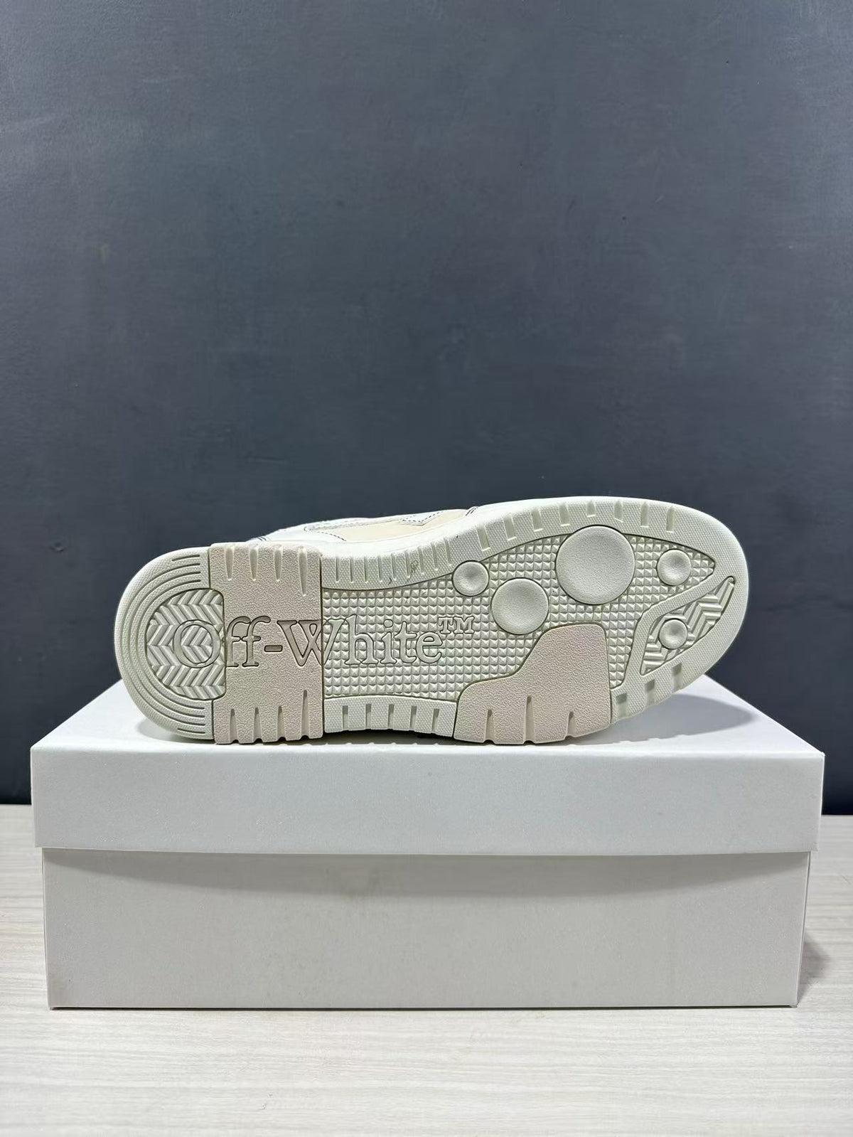Underside of the sneaker showing the textured cream-white rubber outsole and tread pattern.