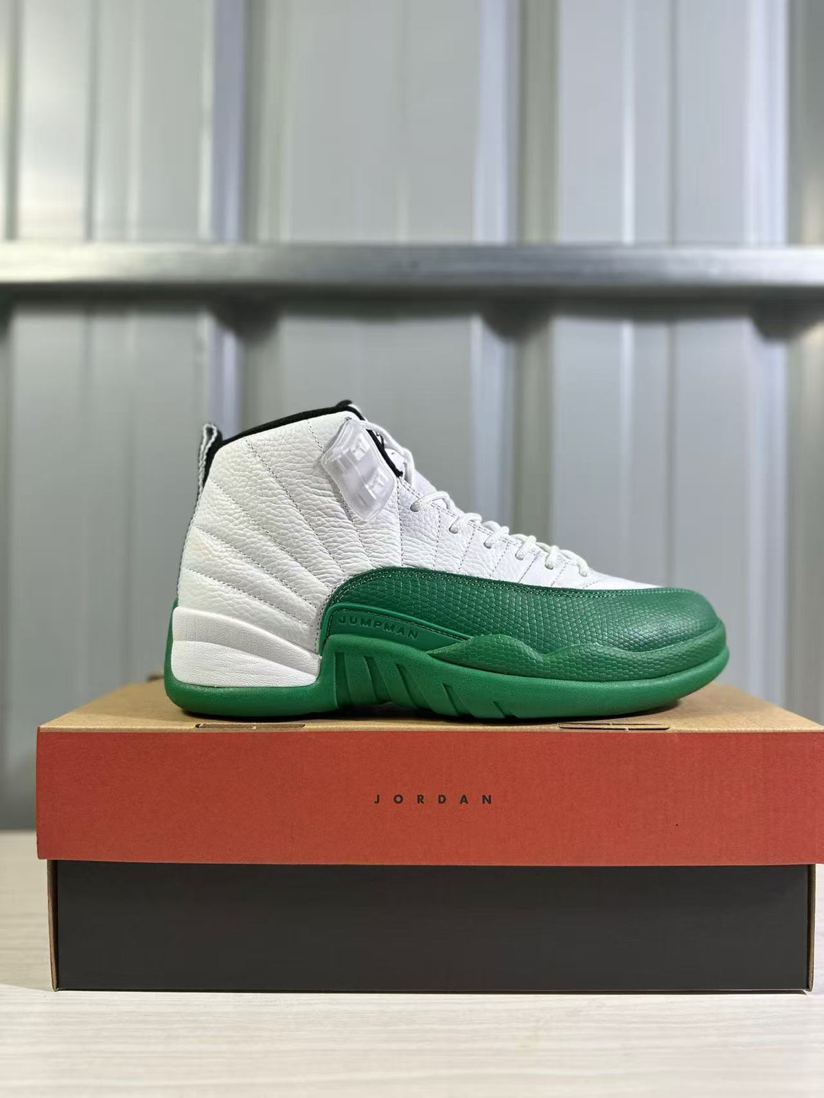 Side profile of a white and green Jordan sneaker displayed on a Jordan shoebox.