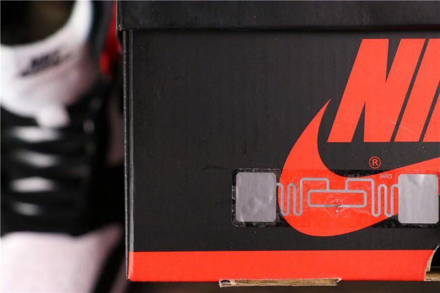 Close-up of a black Jordan-branded shoe box beside the photographed sneakers.