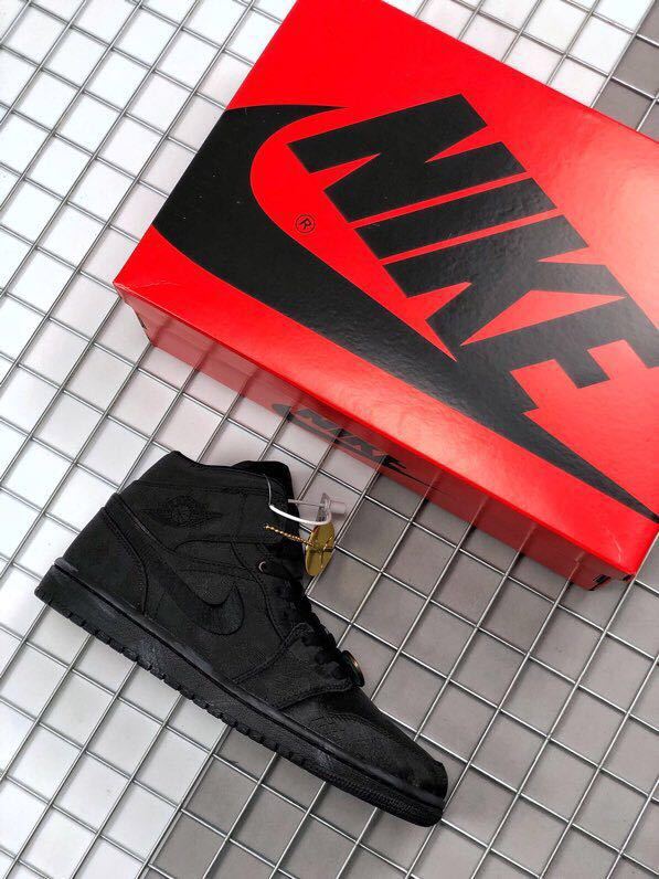 Black high-top sneakers shown beside a red Jordan shoebox.