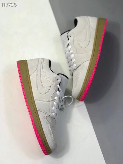 Two sneakers arranged diagonally to show the low-top profile and contrasting gum and pink sole colors.