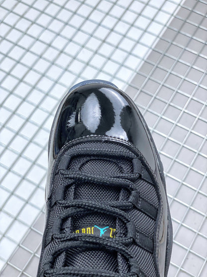 Close-up of the black sneaker toe box, black laces and tongue with blue and yellow branding details.