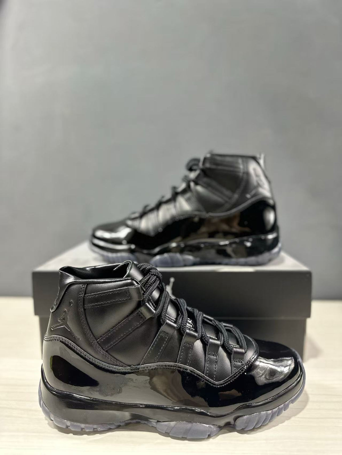 Close view of a black high-top sneaker showing the lacing system, glossy side panels, and translucent outsole.
