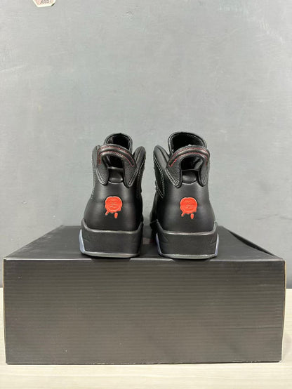 Rear view showing the padded collars and red heel graphics on the black sneakers.