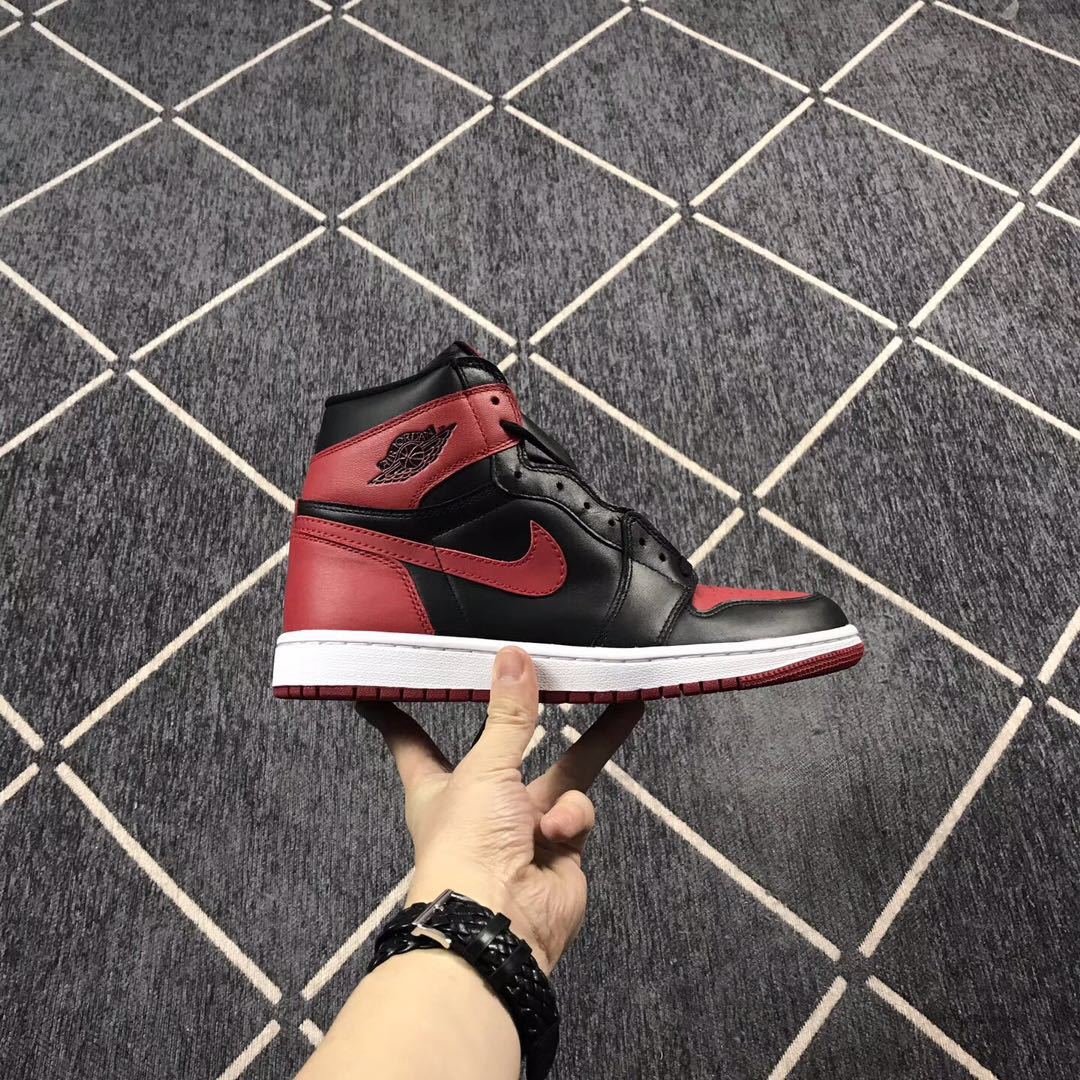 Side profile of a black, red, and white high-top sneaker with a contrasting Swoosh and ankle emblem.