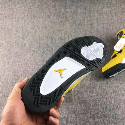 Outsole close-up showing black herringbone-style tread, white traction sections, and a yellow Jumpman emblem.