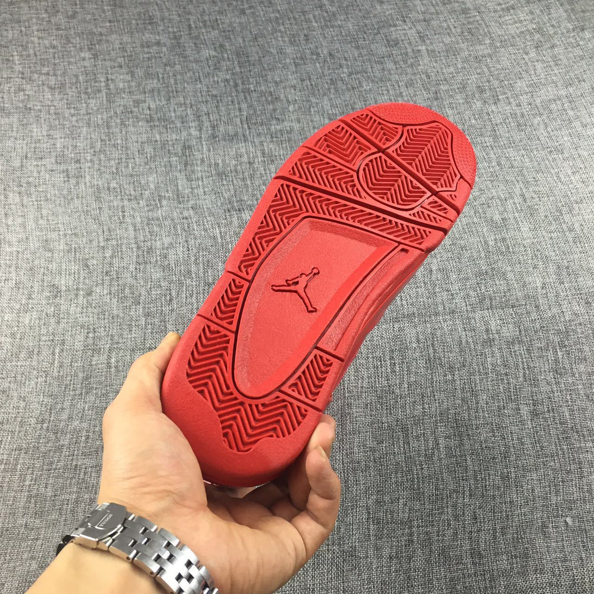 Red outsole with herringbone-style traction sections and a raised Jordan logo.