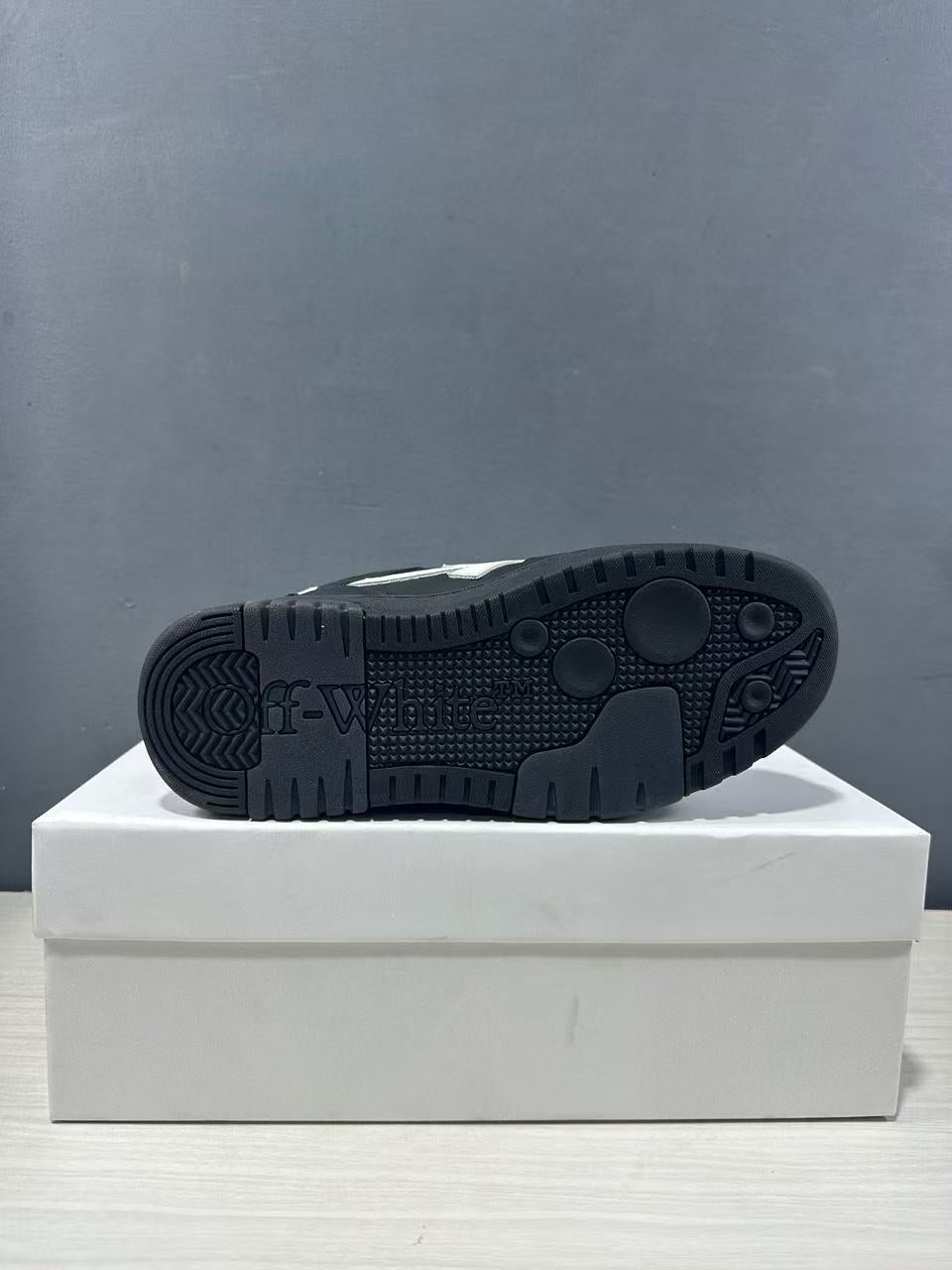 Close view of the black outsole showing its textured tread pattern and embossed branding.