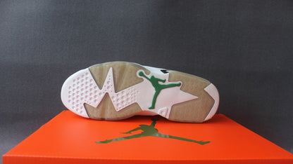 Outsole view showing the white, translucent, and tan traction sections with a green Jumpman logo.