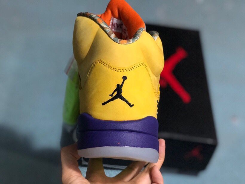 Rear view of the yellow sneaker showing the Jordan logo, purple midsole, and translucent outsole.
