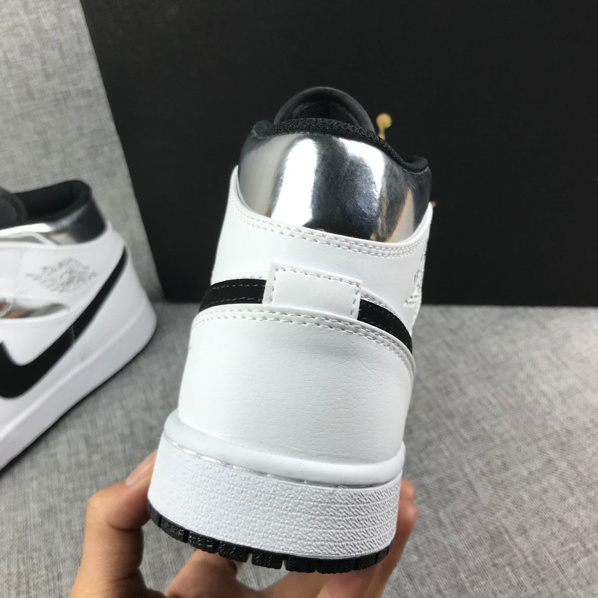 Close-up of the heel showing white construction, black trim, and a metallic silver collar.