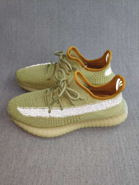 Pair of green Yeezy 350 V2-style sneakers showing reflective side stripes, tonal laces, amber collars, and translucent soles.