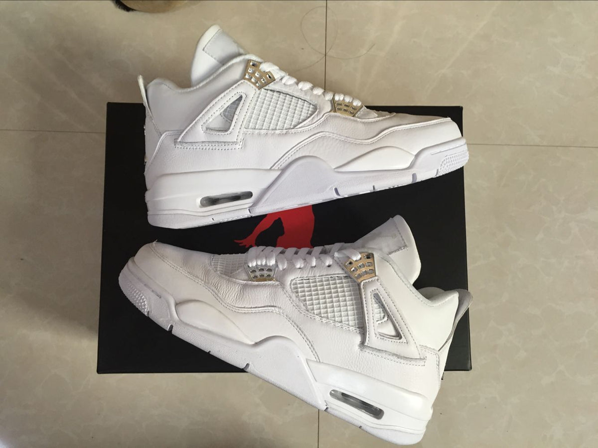 Side view of two white Jordan 4 sneakers showing the layered upper, mesh panels, midsole cushioning window, and outsole profile.